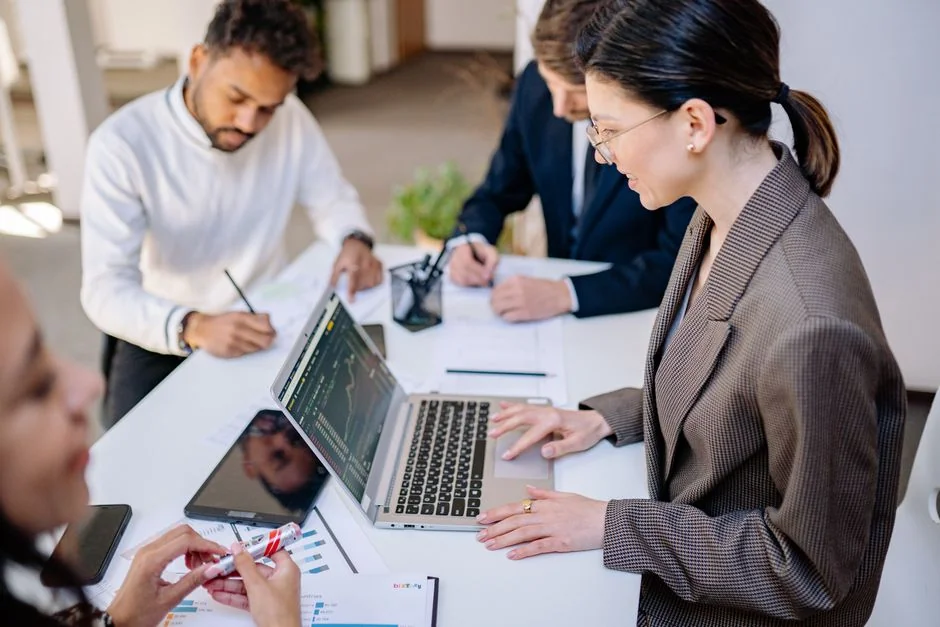 A diverse team collaborating on digital marketing strategies at a desk, using laptops and tablets.